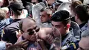 Sejumlah kakek terlibat aksi saling dorong dengan polisi anti huru hara saat menggelar demo di Athena, Yunani, Senin (3/10).  Sekitar 1.500 pensiunan memprotes pemotongan tunjangan pensiun oleh pemerintah Yunani. (REUTERS / Alkis Konstantinidis)
