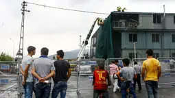 Sejumlah warga melihat kantor polisi yang rusak pasca diserang bom, Istanbul, Turki, Senin (10/8/2015). Sebuah truk bermuatan bahan peledak membombardir kantor polisi yang melukai tiga anggota dan tujuh warga sipil. (REUTERS/Huseyin Aldemir)