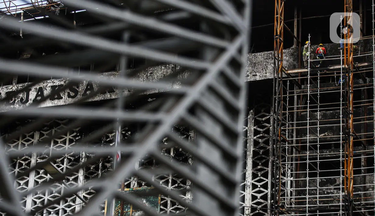 Pekerja memasang 'scaffolding' atau struktur besi untuk melakukan perbaikan Gedung Kejaksaan Agung, Jakarta, yang hangus terbakar, Rabu (7/10/2020).  Kebakaran pada 22 Agustus 2020 lalu mengakibatkan kerusakan berat pada seluruh bangunan Gedung Utama Kejaksaan Agung. (Liputan6.com/Faizal Fanani)