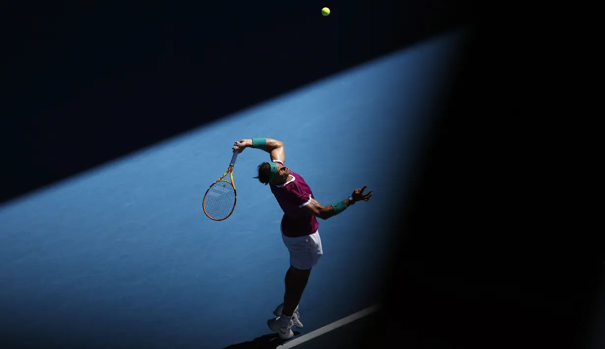 Petenis Spanyol, Rafael Nadal melakukan servis kepada Denis Shapovalov dari Kanada dalam pertandingan perempat final kejuaraan tenis Australia Terbuka di Melbourne, Australia, Selasa, 25 Januari 2022. (AP Photo/Hamish Blair)