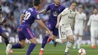 Gelandang Real Madrid, Luka Modric, berusaha melewati pemain Celta Vigo pada laga La Liga 2019 di Stadion Santiago Bernabeu, Sabtu (16/3). Real Madrid menang 2-0 atas Celta Vigo. (AP/Paul White)
