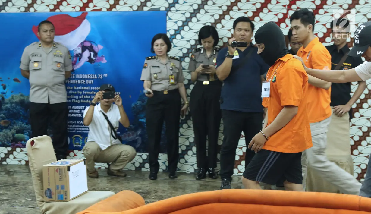 Tersangka HS pelaku kasus pembunuhan satu keluarga di Bekasi digiring untuk melakukan pra-rekonstruksi di Polda Metro Jaya, Jakarta, Senin (19/11). 35 adegan diperagakan dari 57 yang akan diperagakan saat rekonstruksi. (Liputan6.com/Helmi Fithriansyah)