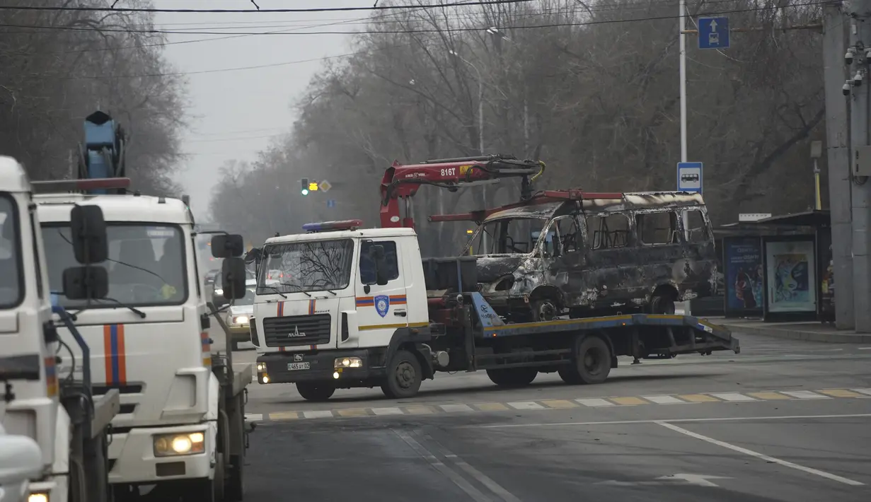 Sebuah truk derek mengangkut sebuah bus, yang terbakar dalam bentrokan di Almaty, Kazakhstan, Minggu (9/1/2022). Kementerian Kesehatan Kazakhstan mengatakan setidaknya 164 orang tewas dalam protes yang mengguncang negara itu selama seminggu terakhir. (Vladimir Tretyakov/NUR.KZ via AP)