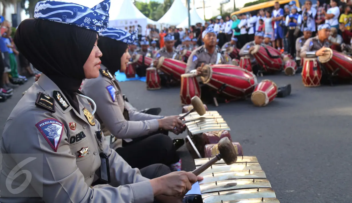 Sejumlah polisi wanita (polwan) memainkan alat musik tradisional, gamelan, pada kegiatan car free day di Jakarta, Minggu (9/4). Dalam atraksi tersebut mereka melakukan sosialisasi “Polwanku Sahabatku”. (Liputan6.com/Angga Yuniar)