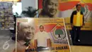 Kader partai menunjukkan hasil fotonya dengan latar belakang gambar Presiden kedua RI, Soeharto disela Musyawarah Nasional Luar Biasa (Munaslub) Partai Golkar di Bali Nusa Dua Convention Center (BNDCC), Bali, Minggu (15/5). (Liputan6.com/Johan Tallo)