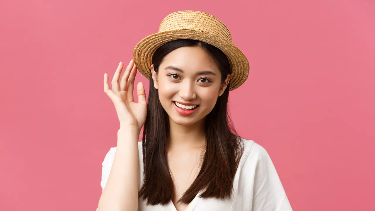 Seorang perempuan menggunakan sebuah topi anyam (Foto Dok: Freepik/benzoix)