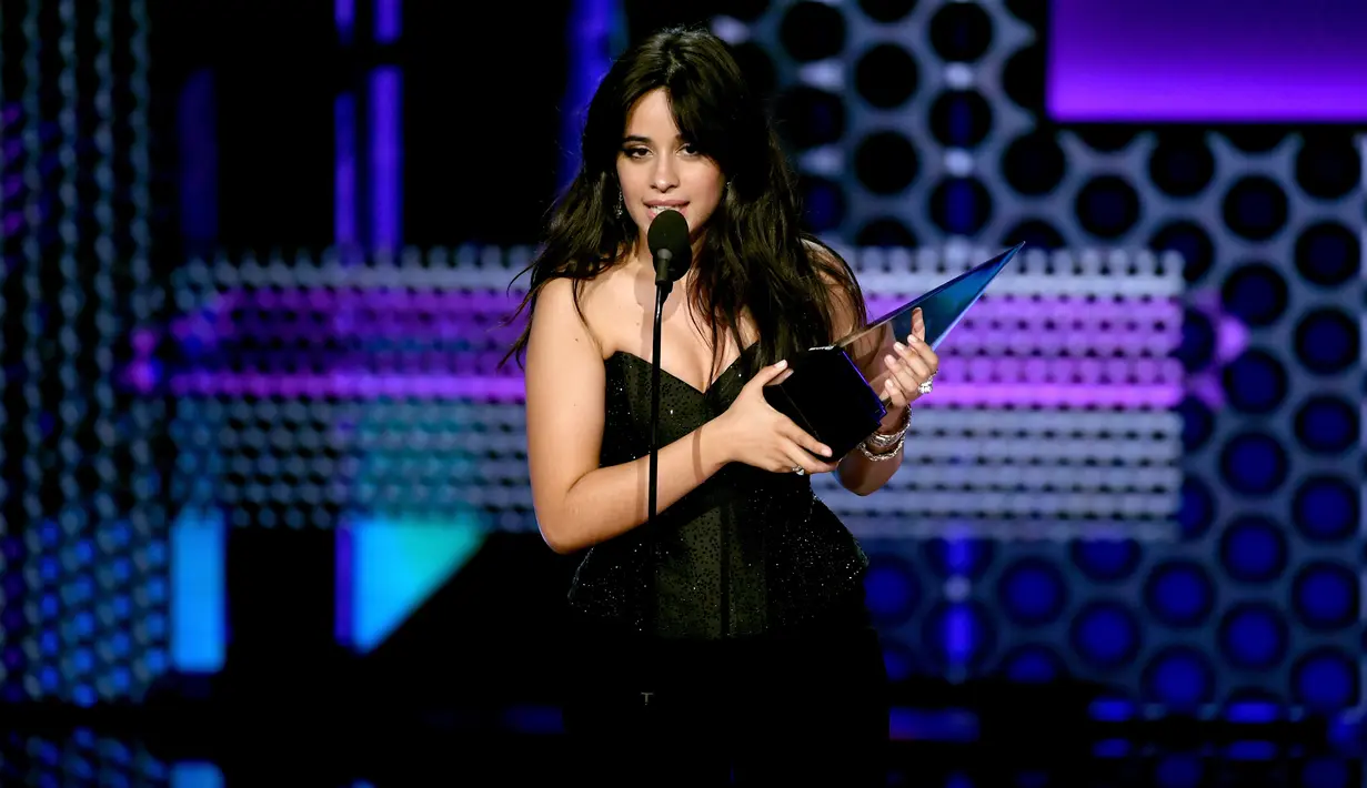 Penyanyi Camila Cabello memberikan pidato saat menerima piala pertamanya pada ajang American Music Awards 2018 di Los Angeles, Selasa (9/10). Lewat lagu 'Havana', Camilla dianugerahi sebagai Lagu Pop/Rock Terfavorit 2018. (Kevin Winter/Getty Images/AFP)