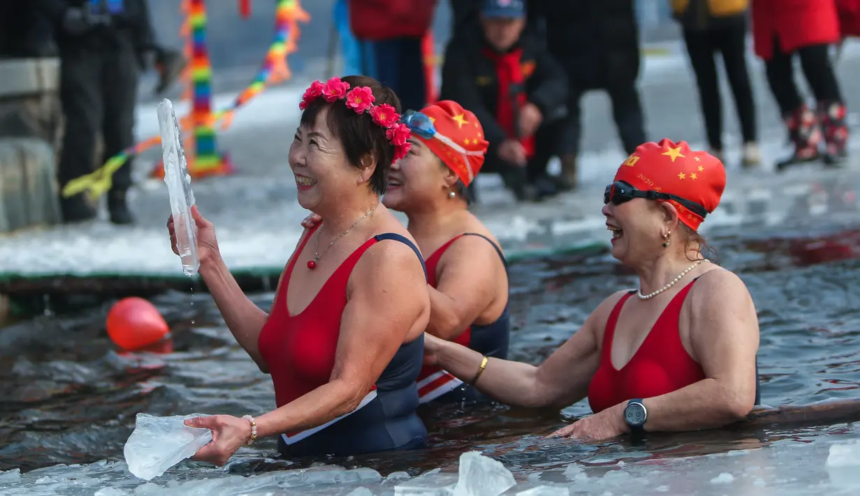 Penggemar renang musim dingin menyelam ke danau yang sebagian beku di Shenyang, di provinsi Liaoning, China pada 25 Januari 2022. Penduduk lokal banyak menggemari kebiasaan berenang di musim dingin di mana banyak sungai dan danau-danau mulai membeku. (STR/AFP)