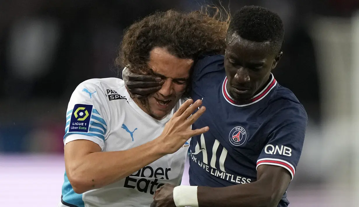 Gelandang Olympique Marseille Matteo Guendouzi berebut bola dengan gelandang Paris Saint-Germain (PSG) Idrissa Gueye pada laga Liga Prancis pekan ke-32 di Parc des Princes, Senin (18/4/2022) dini hari WIB. PSG vs Marseille berakhir dengan skor 2-1. (AP Photo/Francois Mori)