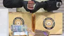 Petugas menunjukkan barang bukti berupa uang tunai yang disita dari Operasi Tangkap Tangan (OTT) terhadap Bupati Cilacap, Jawa Tengah, Syamsul Auliya Rachman, di Gedung Merah Putih Komisi Pemberantasan Korupsi (KPK), Jakarta, Sabtu (14/3/2026). (Liputan6.com/Helmi Fithriansyah)