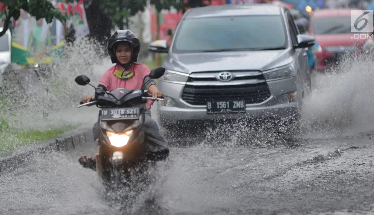 Pengendara bermotor melewati banjir di Jalan Cinere Raya (depan Mall Cinere), Depok, Jawa Barat, Minggu (31/3). Banjir terjadi akibat sistem drainase yang buruk. (merdeka.com/Arie Basuki)