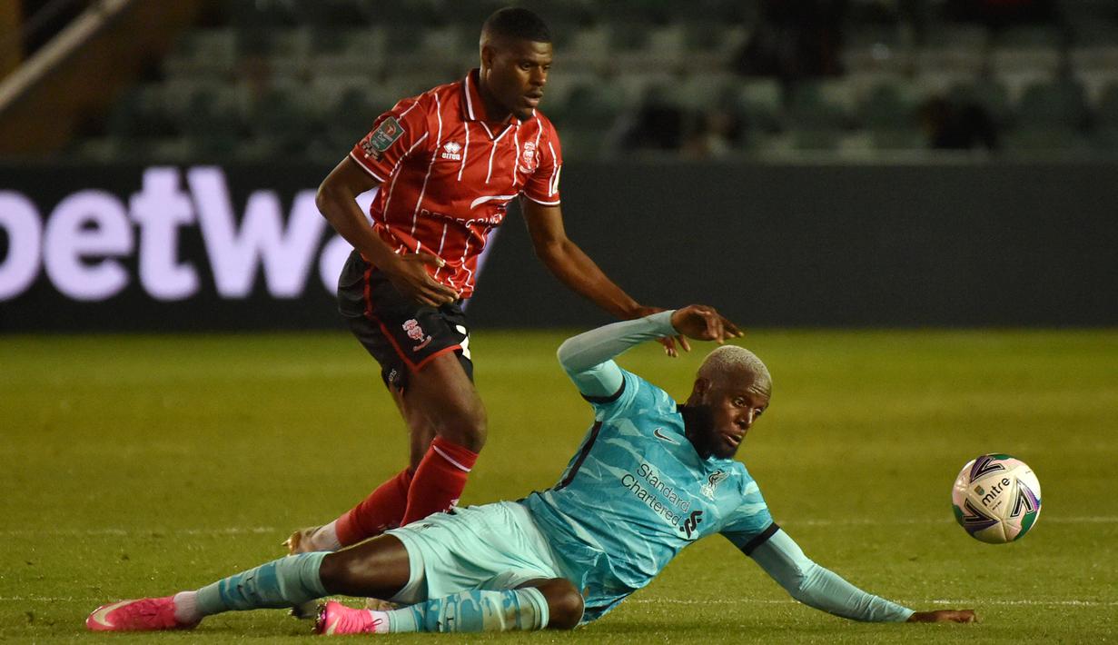 Striker Liverpool, Divock Origi, berebut bola dengan bek Lincoln City, TJ Eyoma, pada babak ketiga Piala Liga Inggris di Sincil Bank Stadium, Jumat (25/9/2020). Liverpool menang telak 7-2 atas Lincoln. (AFP/Rui Vieira/pool)
