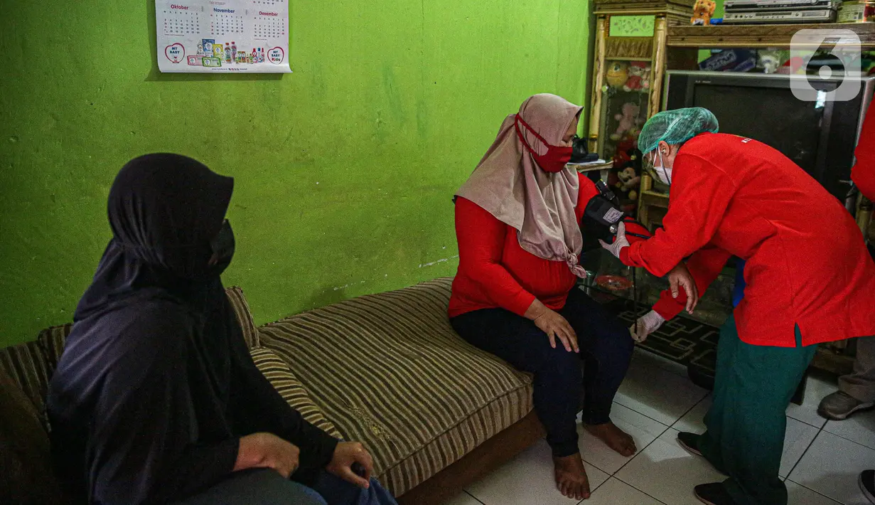 Petugas medis mengecek kesehatan warga sebelum divaksin COVID-19 di Bogor, Jawa Barat, Rabu (14/7/2021). Metode vaksinasi door to door telah mampu meningkatkan partisipasi vaksinasi karena dapat menjangkau keluarga yang belum mempunyai akses dan takut keluar rumah. (Liputan6.com/Faizal Fanani)