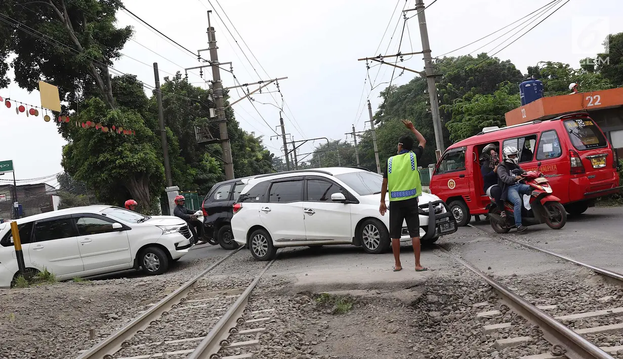 Kendaraan menyeberangi perlintasan kereta api di Lenteng Agung, Jakarta, Selasa (13/3). Untuk mengurai kemacetan imbas antrian kendaraan berputar balik di pintu kereta IISIP, Pemprov DKI berencana membangun flyover U-Turn. (Liputan6.com/Immanuel Antonius)