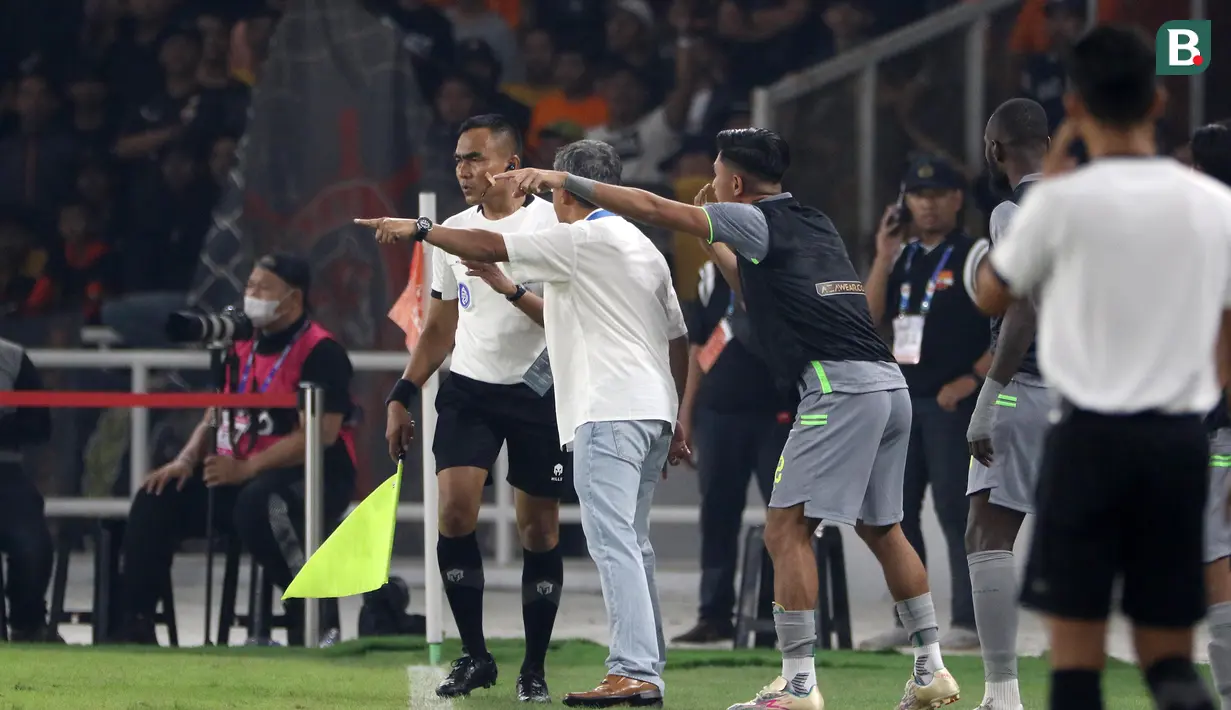 Pelatih Persebaya Surabaya, Aji Santoso (dua kiri), keluar dari teknikal area dan melakukan protes kepada asisten wasit dikarenakan bola umpang pemain Persebaya yang disundul oleh pemain Persija dan keluar dari lapangan tersebut tidak digubris oleh asisten wasit. (Bola.com/Ikhwan Yanuar)