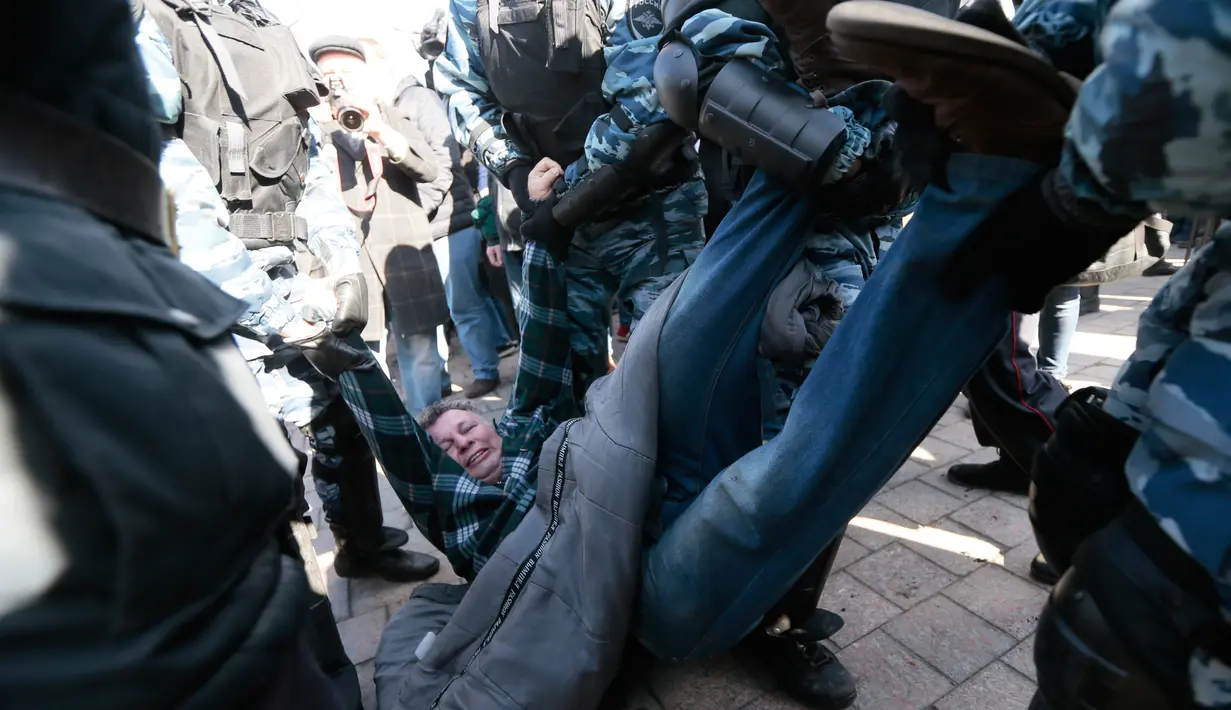 Seorang pengunjuk rasa ditangkap oleh polisi Rusia di tengah unjuk rasa anti-korupsi di pusat kota Moskow, Minggu (26/3). Demo itu diikuti oleh ribuan orang yang menuntut pengunduran diri PM Dmitry Medvedev atas dugaan korupsi (AP Photo/Ivan Sekretarev)