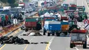 Puluhan traktor berjejer menutupi jalan raya A6 di Limonest, dekat Lyon, Prancis (23/7/2015). Petani Perancis memprotes kembali ketidak seimbangan keuntungan yang diperoleh antara petani dan pengecer. (REUTERS/Robert Pratta)