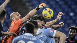 Kiper Lazio, Pepe Reina (kiri), meninju bola dari ancaman pemain Napoli dalam laga lanjutan Liga Italia Serie A 2020/21 pekan ke-13 di Olimpico Stadium, Roma, Minggu (20/12/2020). Lazio mengalahkan Napoli 2-0. (AFP/Filippo Monteforte)