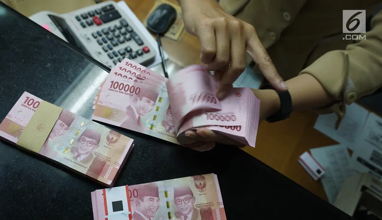 Teller menunjukkan mata uang rupiah di penukaran uang di Jakarta, Rabu (10/7/2019). Nilai tukar rupiah terhadap dolar Amerika Serikat (AS) ditutup stagnan di perdagangan pasar spot hari ini di angka Rp 14.125. (Liputan6.com/Angga Yuniar)