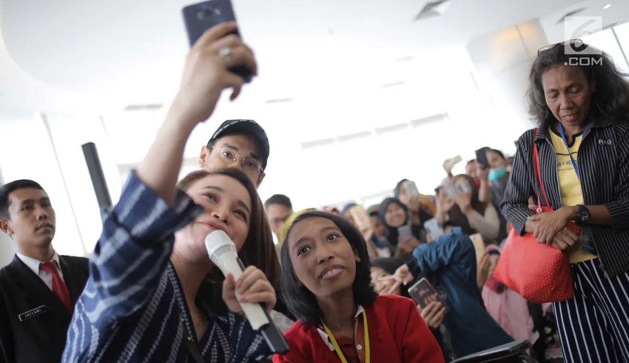 Penyanyi Afgan dan Rossa berselfie dengan seorang anak di RSCM, Jakarta, Senin (28/5). Acara tersebut merayakan ulang tahunnya Afgan yang ke-29 dan sekaligus menghibur pasien anak-anak. (Liputan6.com/Faizal Fanani)