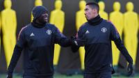 Pemain Manchester United, Romelu Lukaku berbincang dengan Chris Smalling saat mengikiuti sesi latihan jelang laga Liga Champions di Manchester, Senin (4/12/2017). Manchester United akan berhadapan dengan CSKA Moscow. (AFP/Paul Ellis)