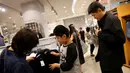. Orang-orang berbelanja pakaian hitam atau putih untuk menghadiri penghormatan terakhir atas meninggalnya Raja Thailand Bhumibol Adulyadej di sebuah mall Bangkok, Thailand (15/10). (REUTERS / Edgar Su)