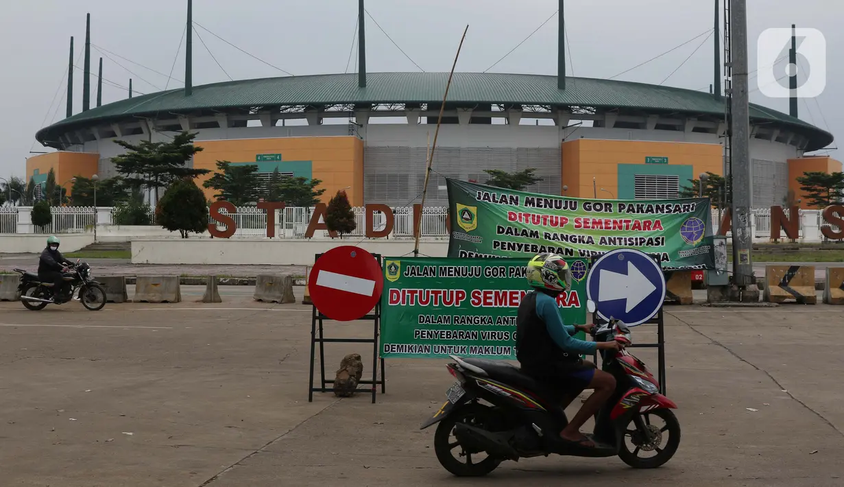Pengendara motor melintasi jalan depan Stadion Pakansari, Kab Bogor, Jawa Barat, Senin (13/4/2020). Bupati Bogor Ade Yasin menyatakan Pembatasan Sosial Berskala Besar pencegahan penularan virus COVID-19 akan fokus di 11 kecamatan yang masuk kategori zona merah. (Liputan6.com/Helmi Fithriansyah)