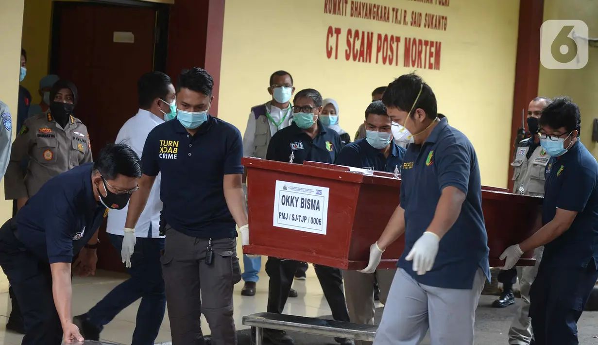 Petugas membawa peti jenazah berisi korban kecelakaan Sriwijaya Air SJ 182 atas nama Okky Bisma menuju mobil ambulans saat serah terima kepada pihak keluarga di RS Polri, Jakarta, Kamis (14/1/2021). Okky Bisma menjadi korban pertama yang berhasil teridentifikasi. (merdeka.com/Imam Buhori)