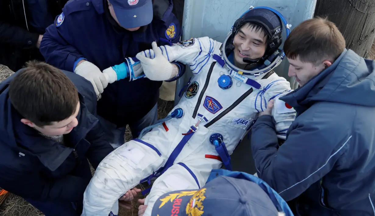 Regu penyelamat badan antariksa Rusia membantu awak Stasiun Luar Angkasa Takuya Onishi dari Jepang setelah keluar dari Kapsul Soyuz MS yang berhasil mendarat di  Dzhezkazgan, Kazakhstan (30/10). (Reuters/Dmitri Lovetsky)
