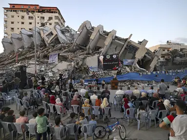 Musisi Palestina tampil di puing-puing Menara Hanadi di Kota Gaza (2/6/2021). Acara diselenggarakan oleh Komite Pemuda dan Kebudayaan Palestina lebih dari seminggu setelah gencatan senjata mengakhiri 11 hari permusuhan antara Israel dan Hamas. (AFP Photo/Mohammed Abed)