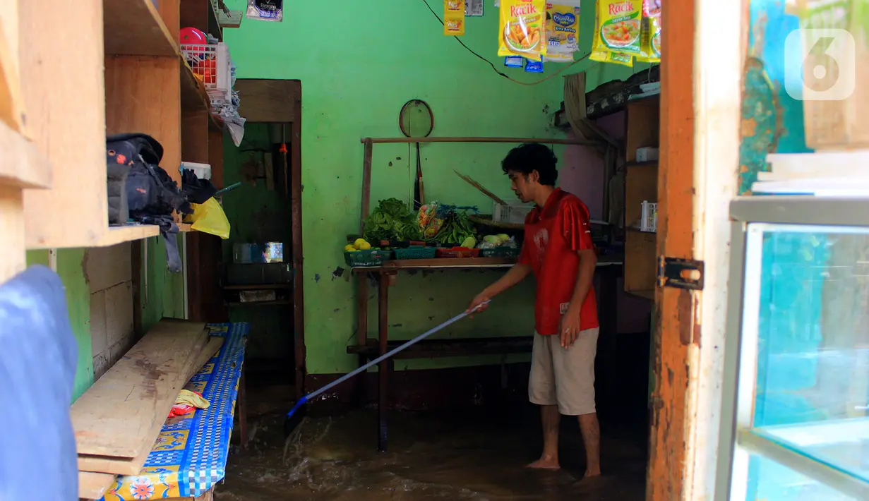 Warga membersihkan lumpur sisa banjir di kawasan Bidara Cina, Kecamatan Jatinegara, Jakarta Timur, Selasa (25/2/2020). Baru satu hari air surut, kawasan Bidara Cina yang bersebelahan dengan Kali Ciliwung kembali mengalami banjir. (merdeka.com/magang/ Muhammad Fayyadh)