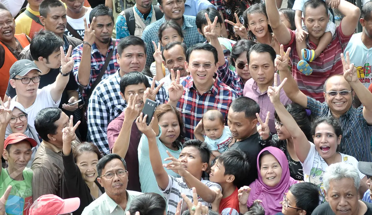 Cagub DKI Basuki Tjahaja Purnama ( Ahok ) berpose bersama warga saat blusukan ke wilayah Cililitan, Jakarta, Rabu (28/12). Dalam blusukannya tersebut Ahok mencari tahu permasalahan banjir di Cililitan Kecil. (Liputan6.com/Yoppy Renato)