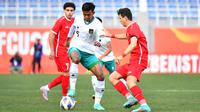 Pemain Timnas Indonesia U-20, Kakang Rudianto (kiri) berebut bola dengan pemain Suriah U-20, Amer Alfayad pada laga matchday kedua Grup A Piala Asia U-20 2023 di Lokomotiv Stadium, Tashkent, Uzbekistan, Sabtu (4/3/2023). (AFC/Adam Aidil)