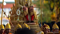 Raja Thailand Maha Vajiralongkorn diarak menggunakan tandu keliling Kota Bangkok, Thailand, Minggu (5/5/2019). Raja Vajiralongkorn yang bergelar Rama X dari Dinasti Chakri mengenakan jubah berhiaskan berlian. (AP Photo/Wason Wanichorn)