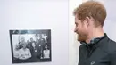 Pangeran Harry, melihat foto almarhum ibunya,  Putri Diana setelah tiba di badan amal Depaul di London,Inggris, (26/1). Pangeran Harry bersama relawan dan tunawisma berlari selama 17 menit dalam amal ini. (Geoff Pugh, Foto Renang via AP)