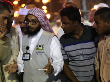 Jemaah haji berbincang dengan seorang penerjemah di kota suci Islam, Makkah, 17 Agustus 2018. Pemerintah Arab Saudi mengerahkan para penerjemah dari berbagai bahasa yang bekerja 24 jam per hari untuk membantu para jemaah. (AFP/AHMAD AL-RUBAYE)