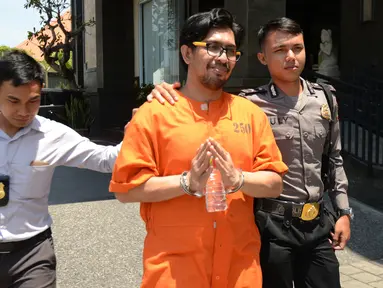 Mohd Husaini Jaslee dari Malaysia dikawal polisi setelah konferensi pers menyusul penahanannya di kantor pabean di Bandara Ngurah Rai, Denpasar, Bali (4/10). Jaslee ditangkap setelah membawah pil ekstasi di dalam tas laptopnya. (AFP Photo/Sonny Tumbelaka)