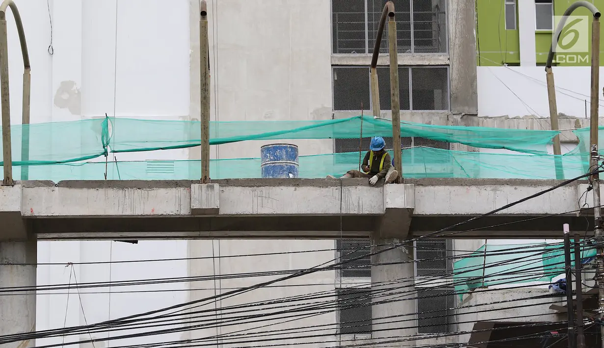Pekerja menyelesaikan pembangunan JPO Pasar Rumput di Jakarta, Selasa (15/1). Pembangunan jembatan di bangunan pasar yang terintegrasi dengan rusun tersebut dibuat untuk memudahkan mobilitas warga. (Liputan6.com/Immanuel Antonius)