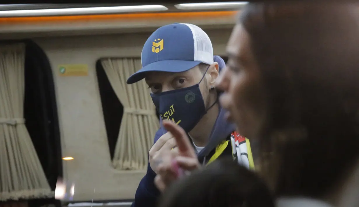 Gelandang Jerman, Mesut Ozil mengenakan masker berada di dalam sebuah van setelah tiba di Bandara Ataturk di Istanbul (18/1/2021). Ozil diklaim akan menandatangani kontrak tiga tahun bersama Fenerbahce.  (AP Photo)