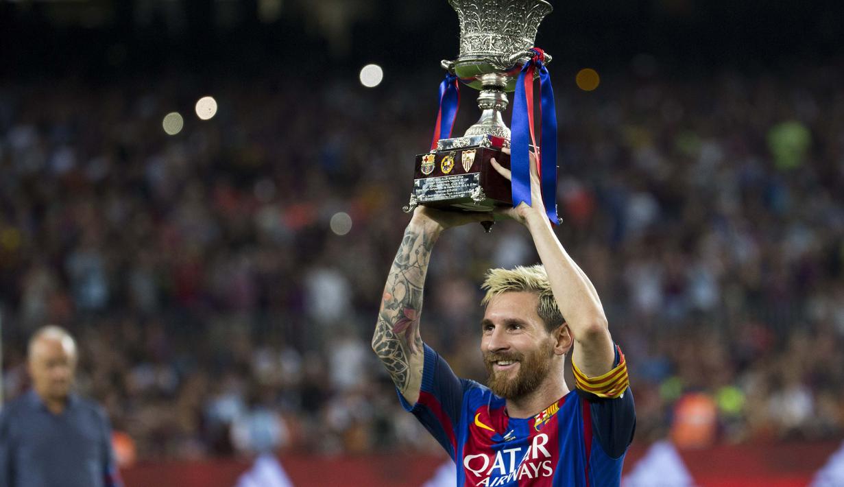 Lionel Messi mengangkat trofi  Super Cup Spanyol usai timnya menang aggregat 5-0 atas Sevilla di Stadion Camp Nou, Barcelona (18/8/2016). (EPA/Quique Garcia)