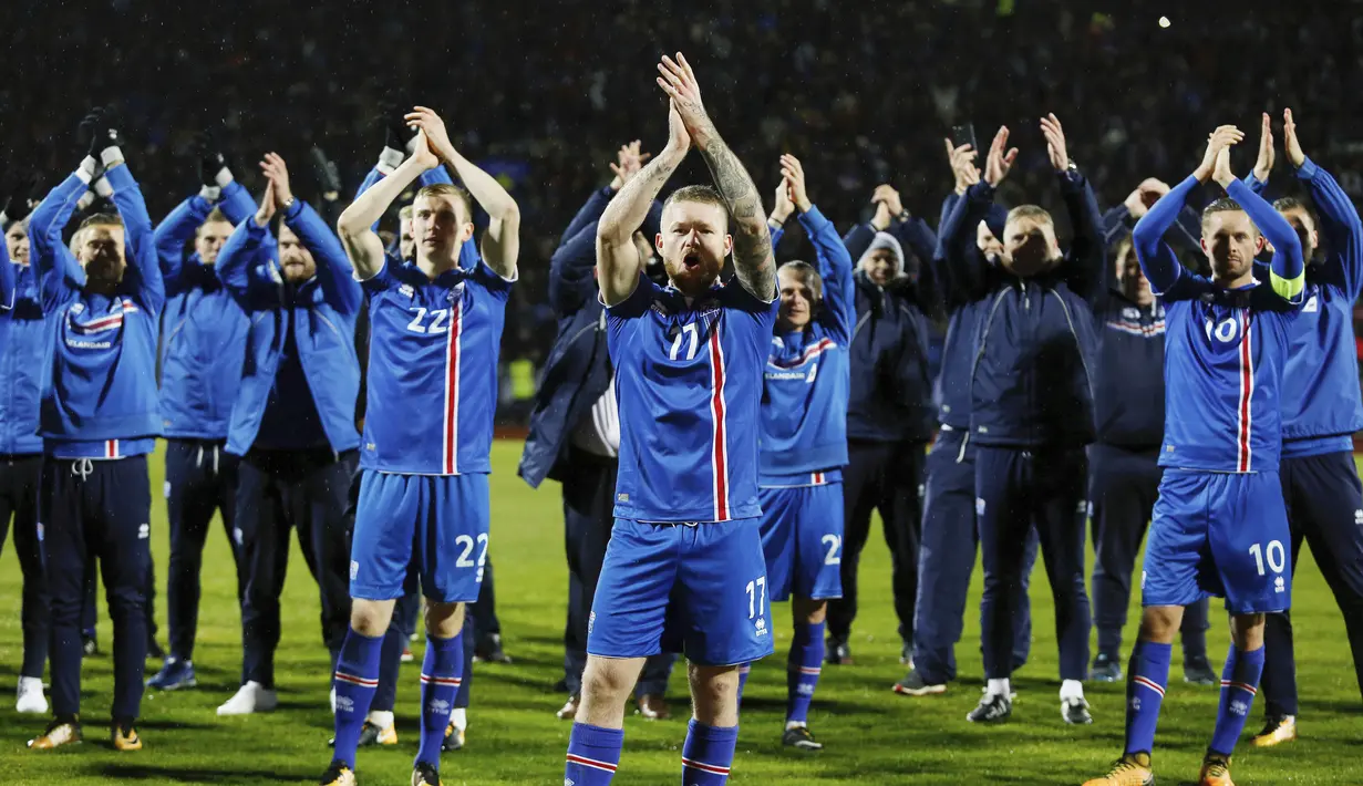 Kapten Islandia, Aron Gunnarsson, bersama rekan- rekan nya melakukan selebrasi usai memastikan negaranya lolos Piala Dunia 2018 di Stadion Laugardalsvöllur, Senin (9/10/2017). Islandia menang 2-0 atas Kosovo. (AP/Brynjar Gunnarsson)