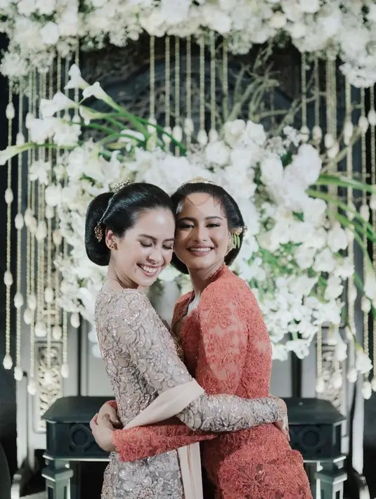 Sama-sama mengenakan kebaya, keduanya menampilkan sosok perempuan Jawa yang ayu. Maudy berkebaya cokelat lengan panjang, lengkap dengan tata rambut yang digelung dan hair-pieces, serta selendang tipis yang serasi dengan kebayanya, sedangkan Amanda memilih kebaya berwarna merah tomat, sama-sama dengan tatanan rambut, hair-pieces, dan riasan yang memperkuat nuansa putri Jawa. Foto: Instagram.