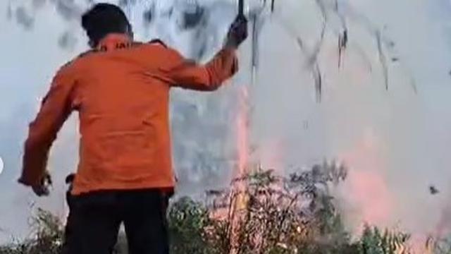 Petugas berusaha memadamkan api yang membakar ilalang di kawasan Gunung Bromo. (Istimewa)