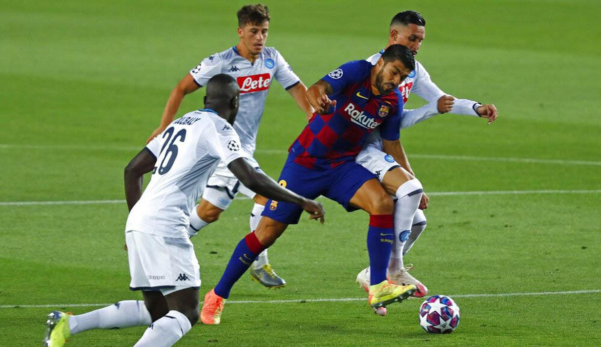 Striker Barcelona, Luis Suarez, berusaha melewati pemain Napoli pada laga Liga Champions di Stadion Camp Nou, Sabtu (8/8/2020). Barcelona menang 3-1 atas Napoli. (AP/Joan Monfort)