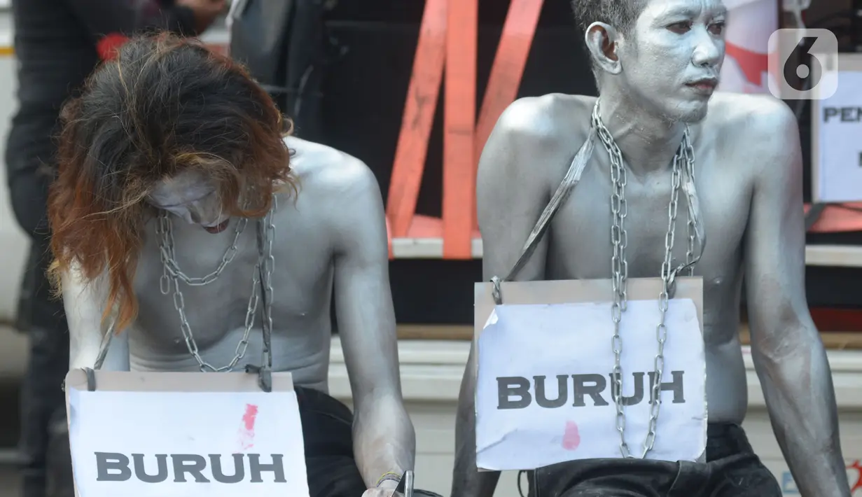 Pengunjuk rasa dari berbagai elemen buruh melakukan teatrikal saat unjuk rasa di kawasan Patung Kuda, Jakarta, Rabu (8/12/2021). Dalam aksinya tersebut mereka meminta pemerintah dan DPR mencabut Undang-undang Nomor 11 Tahun 2020 tentang Cipta Kerja. (merdeka.com/Imam Buhori)