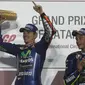 Pembalap Movistar Yamaha, Maverick Vinales bersama rekan setimnya, Valentino Rossi merayakan kemenangannya di atas podium MotoGP Qatar di Sirkuit Losail, Doha, Minggu (26/3). Maverick Vinales keluar sebagai juara MotoGP Qatar. (Karim JAAFAR/AFP)