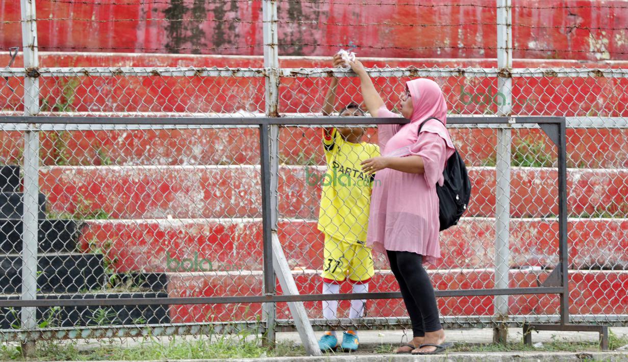Orang tua setia menemani berbagi makanan dan minuman dengan Anak sebelum beraksi Legenda Timnas Indonesia pada Irman Gusman Cup 2016 di Stadion Agus Salim, Padang, Minggu (13/3/2016). (Bola.com/Nicklas Hanoatubun)