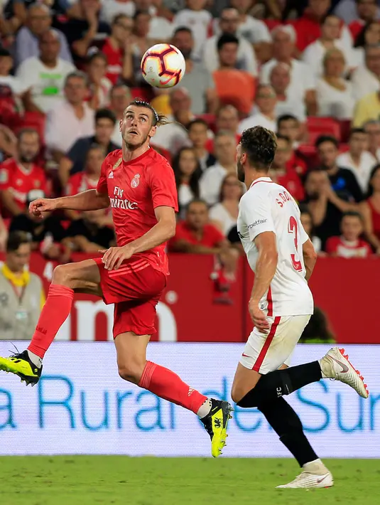 Gelandang Real Madrid, Gareth Bale berusaha mengontrol bola dari kawalan pemain Sevilla Sergi Gomez saat bertanding pada lanjutan La Liga Spanyol di stadion Sanchez Pizjuan (26/9).  Sevilla menang telak 3-0 atas Madrid. (AP Photo/Miguel Morenatti)