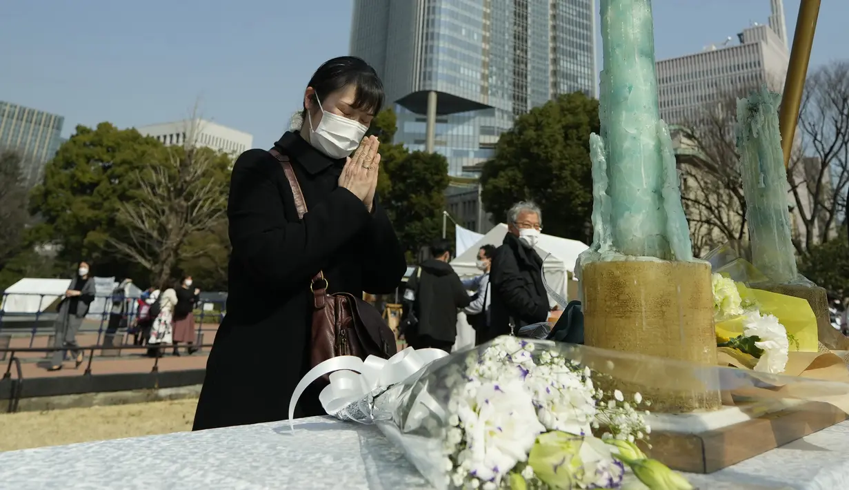 Pengunjung berdoa di altar darurat untuk berkabung bagi korban gempa bumi dan tsunami 11 Maret 2011 dalam acara peringatan khusus di Tokyo, Jumat (11/3/2022). Jepang menandai peringatan 11 tahun gempa bumi, tsunami dan bencana nuklir yang melanda pantai timur laut Jepang. (AP Photo/Eugene Hoshiko)