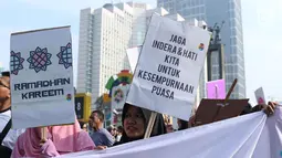 Beragam tulisan menyambut datangnya bulan Ramadan dibawa sejumlah remaja saat acara Car Free Day di Bundaran Hotel Indonesia, Jakarta, Minggu (13/5). Mereka mengajak warga untuk menyambut bulan suci bagi umat muslim. (Liputan6.com/Helmi Fithriansyah)